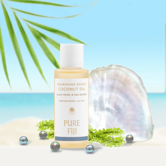 Coconut oil bottle with shell and pearls on a beach background