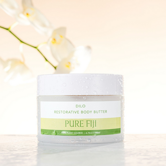 Jar of Pure Fiji body butter with white flowers in the background